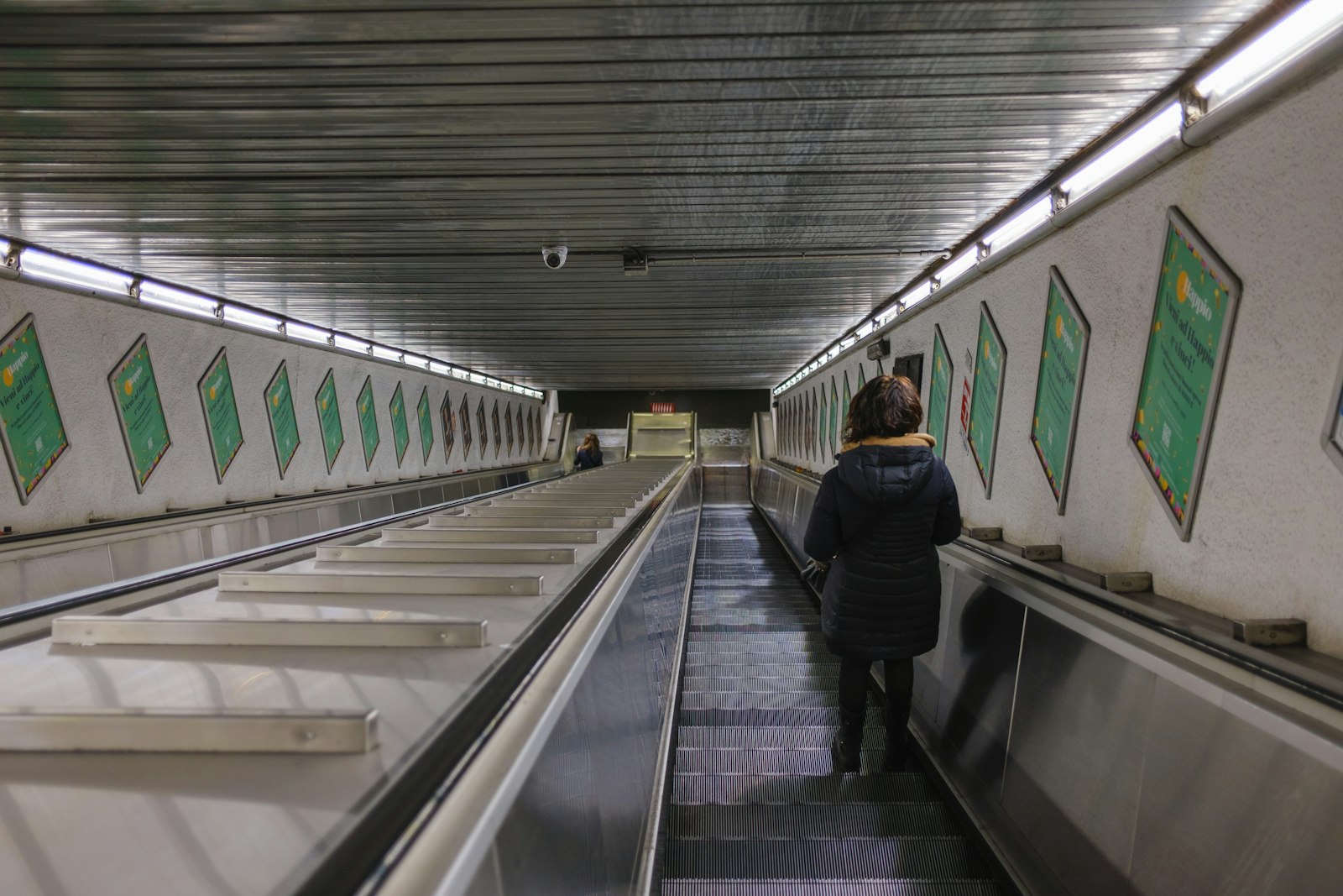 A long escalator going down into a Rome metro station